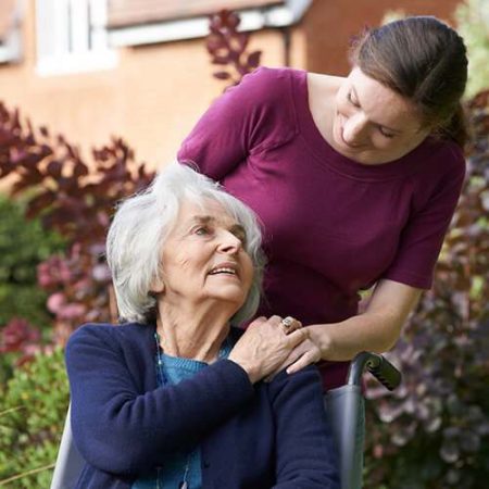 A homecare provider showing compassion to an aged woman